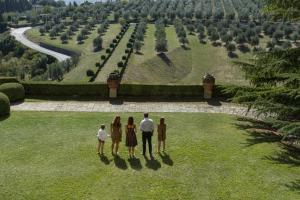 a group of people standing in the grass looking at a garden at Casavilla Rentals by Torre a Cona in Rignano sullʼArno