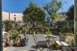 een patio met een tafel en stoelen en potplanten bij ,,La Chaumière d’Azur” in Roquebrune-Cap-Martin