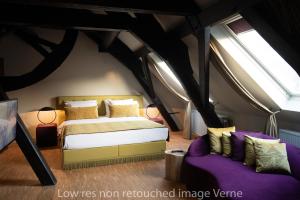 a bedroom with a bed and a purple couch at Hotel 'T Sandt in Antwerp