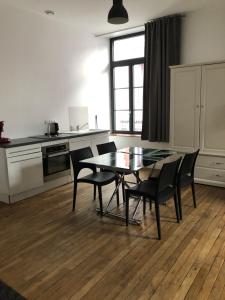 une salle à manger avec une table et des chaises dans une cuisine dans l'établissement Som-home, à Péronne