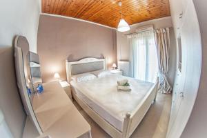a small bedroom with a white bed and a mirror at Marabu Seaview Apartments in Nótos