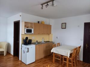 uma cozinha com uma mesa e um frigorífico branco em Apartmán Bára em Cesky Krumlov