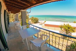 a balcony with tables and chairs and a view of the ocean at Marabu Seaview Apartments in Nótos