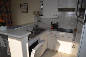 a kitchen with white cabinets and a sink at duinenveld in Nieuwpoort
