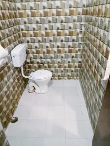 a bathroom with a toilet in a room with tiles at Hotel marwari niwas in Haridwār +64 photos