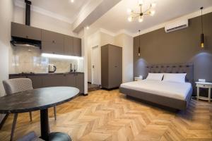 ein Schlafzimmer mit einem Bett und einem Tisch sowie eine Küche in der Unterkunft DayFlat Apartments on Mykhailivs'ka in Kiew