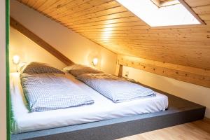 a bed in a attic with two pillows on it at Das Nordberg Apartments in Garmisch-Partenkirchen