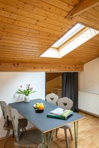 a dining room with a blue table and a skylight at Das Nordberg Apartments in Garmisch-Partenkirchen