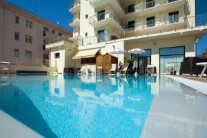 a large swimming pool in front of a building at Excelsior Hotel E Appartamenti in Loano