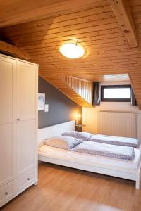 two beds in a bedroom with a wooden ceiling at Das Nordberg Apartments in Garmisch-Partenkirchen