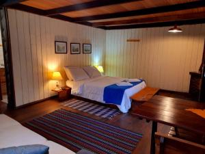 ein Schlafzimmer mit einem Bett und einem Tisch darin in der Unterkunft Hotel Refazenda in Visconde De Maua