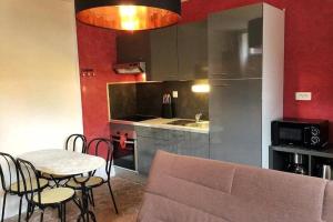 a kitchen with a table and chairs and a kitchen with red walls at La Dolce Vita des Hautes Côtes in Magny-lès-Villers