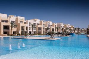 einem großen Pool vor einem Gebäude in der Unterkunft Gleaming 1 BR Apt Mangroovy w Pool & Beach Access in Hurghada