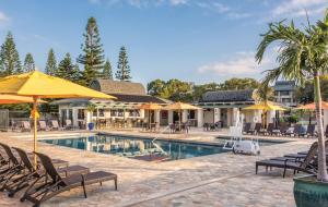 uma piscina num resort com cadeiras e guarda-sóis em Paniolo Greens Resort em Waikoloa