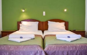 a bedroom with two beds with white pillows at Panorama Hotel in Falasarna