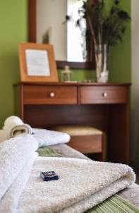 a close up of a bed with a dresser with a mirror at Panorama Hotel in Falasarna