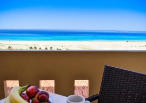 a table with a bowl of fruit and a view of the beach at Panorama Hotel in Falasarna