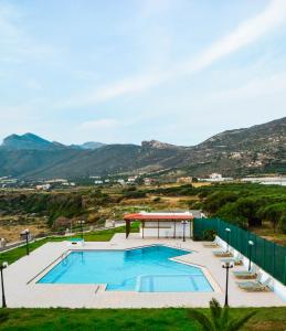 a swimming pool with a gazebo and mountains at Panorama Hotel in Falasarna