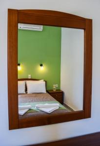 a mirror reflecting a bed in a bedroom at Panorama Hotel in Falasarna
