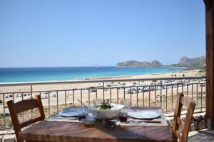 a table on a balcony with a view of the beach at Panorama Hotel in Falasarna