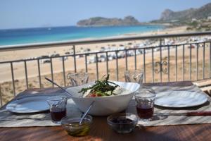 a bowl of salad on a table with a view of the beach at Panorama Hotel in Falasarna