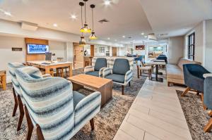 una sala de espera en un hospital con sillas y mesas en Staybridge Suites - Cedar Rapids North, an IHG Hotel, en Cedar Rapids