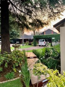 a garden with a white van parked in a parking lot at Diamond Rose Guest House in Middelburg