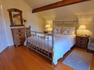 a bedroom with a bed and a dresser and a mirror at Gorse Hill Farm in Newcastle