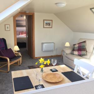 sala de estar con sofá y mesa en Skye Getaways Self Catering Accommodation, en Dunvegan
