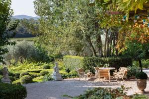 eine Terrasse mit einem Tisch und Stühlen im Garten in der Unterkunft Bastide Barbeiranne in Pignans