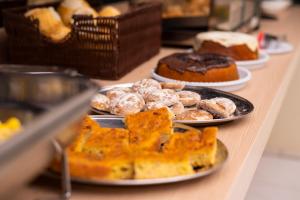 a buffet line with plates of pastries and cakes at Rotta Hotel in Tangara da Serra