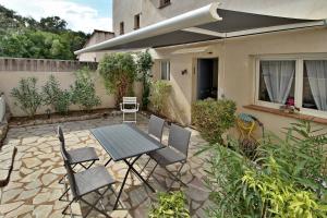 ポルト・ヴェッキオにあるAppartement T2 Prunello By Intendance Excellencyの家の前にテーブルと椅子が置かれたパティオ +4枚の写真