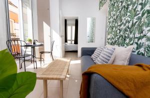 sala de estar con sofá azul y mesa en Apartamentos Juan de Padilla, en Málaga
