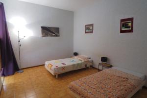 a bedroom with two beds and a lamp in it at Le gite de Modestine in Boucoiran-et-Nozières