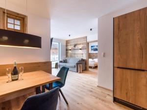 kuchnia i salon z drewnianym stołem i krzesłami w obiekcie FamilienWohnung Wildspitze w mieście Fügen