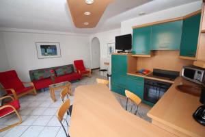 uma cozinha com armários verdes e uma sala de estar em Gîte Lion d'Or em Le Bonhomme