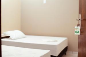 a small room with a bed with a sign on the door at Rotta Hotel in Tangara da Serra