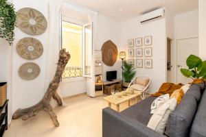 Sala de estar con sofá gris y mesa en Apartamentos Juan de Padilla, en Málaga