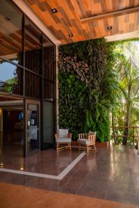 an outdoor patio with chairs and a green wall at Hotel Saint George in Puerto Iguazú