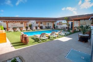 een achtertuin met een zwembad en stoelen en een huis bij Casa Mercedes in El Río
