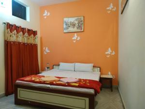 普什卡的住宿－Keshav Palace，一间卧室配有橙色墙壁的床