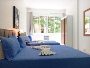 1 Schlafzimmer mit 2 Betten und blauer Bettwäsche in der Unterkunft TC308 Studio na Praia - Espaçoso e aconchegante in Rio de Janeiro