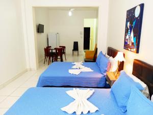 2 Betten in einem Zimmer mit blauer Bettwäsche und Seestern darauf in der Unterkunft TC308 Studio na Praia - Espaçoso e aconchegante in Rio de Janeiro