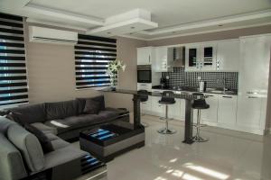 a living room with a couch and a kitchen at Penthouse, 3 Schlafzimmern, Meerblick, Alanya, Kestel in Alanya