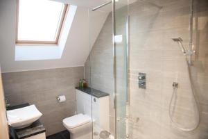 a bathroom with a shower and a toilet and a sink at Homelands Apartment in Cheltenham