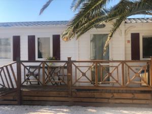 a wooden deck in front of a house at FLAMANTS ROSES 1 pers 6 in Frontignan