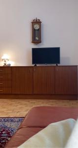 a room with a tv and a clock on a wall at Landhaus nähe Neusiedler See in Jois