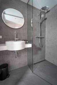 a bathroom with a shower, sink, and mirror at Motel One Copenhagen in Copenhagen