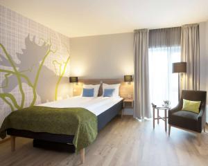 ein Hotelzimmer mit einem Bett und einem Stuhl in der Unterkunft Thon Partner Elgstua Hotel in Elverum