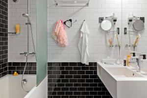y baño con lavabo, ducha y bañera. en Scandic Paasi, en Helsinki